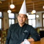 man in black nike jacket wearing white cap