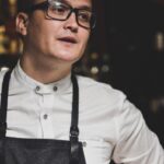 man in white dress shirt and black denim dungarees